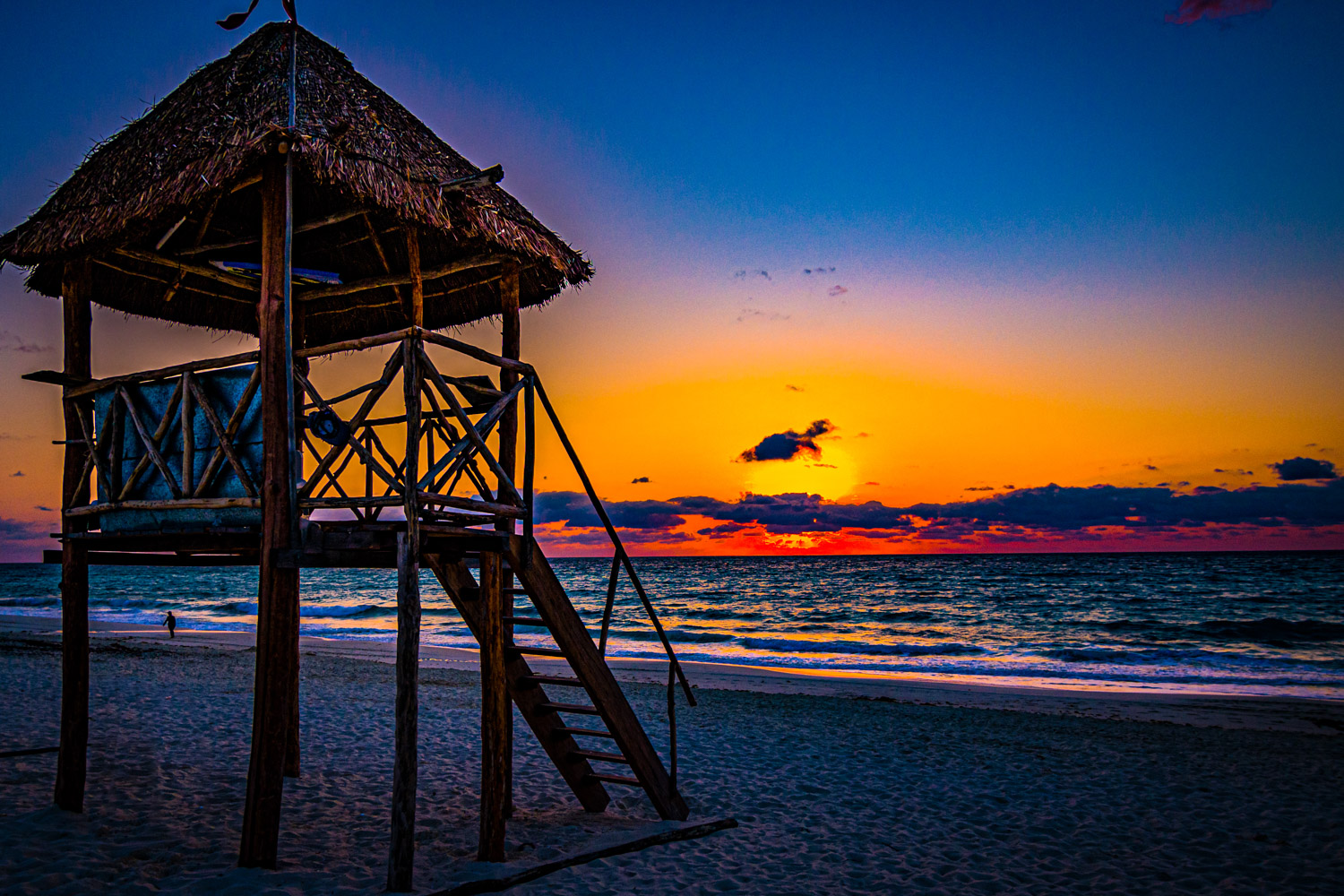 A vibrant, colorful sunrise with a reflection on the ocean with clouds on the horizon including a cloud in the image of a turtle...
